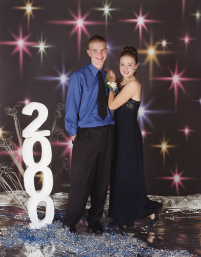 A young couple dressed elegantly in front of a starry backdrop with '200' balloons.