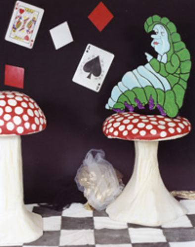Decorative mushrooms and playing cards with a crystal on display.