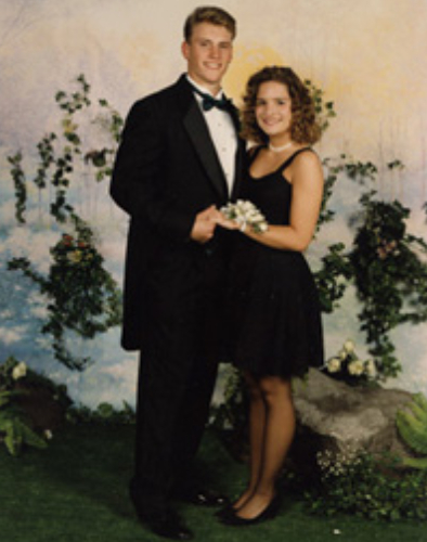 A couple dressed elegantly posing for a formal photo.