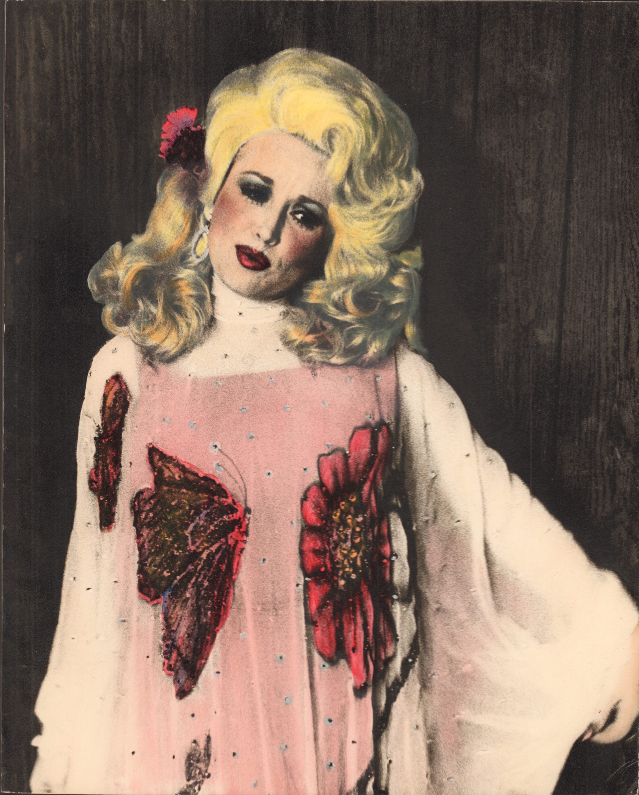 Person in dramatic makeup and blonde wig wearing a blood-stained sweater with butterfly designs.